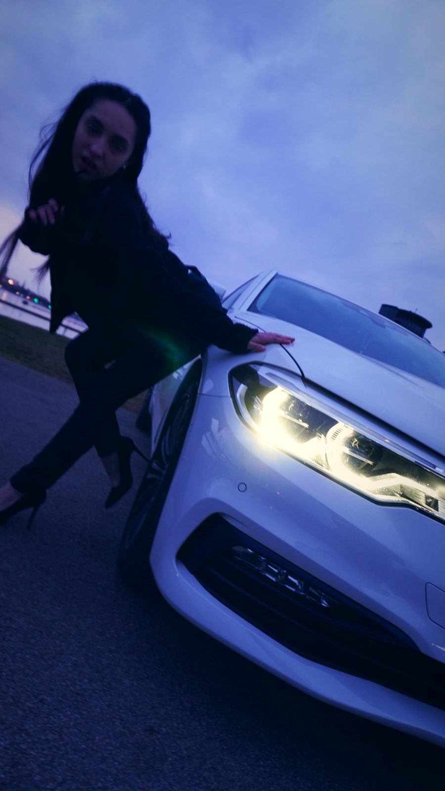 Девушка у горящей фары BMW с бликом