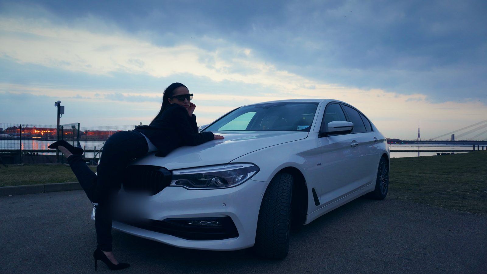 Девушка лежит на капоте белого BMW