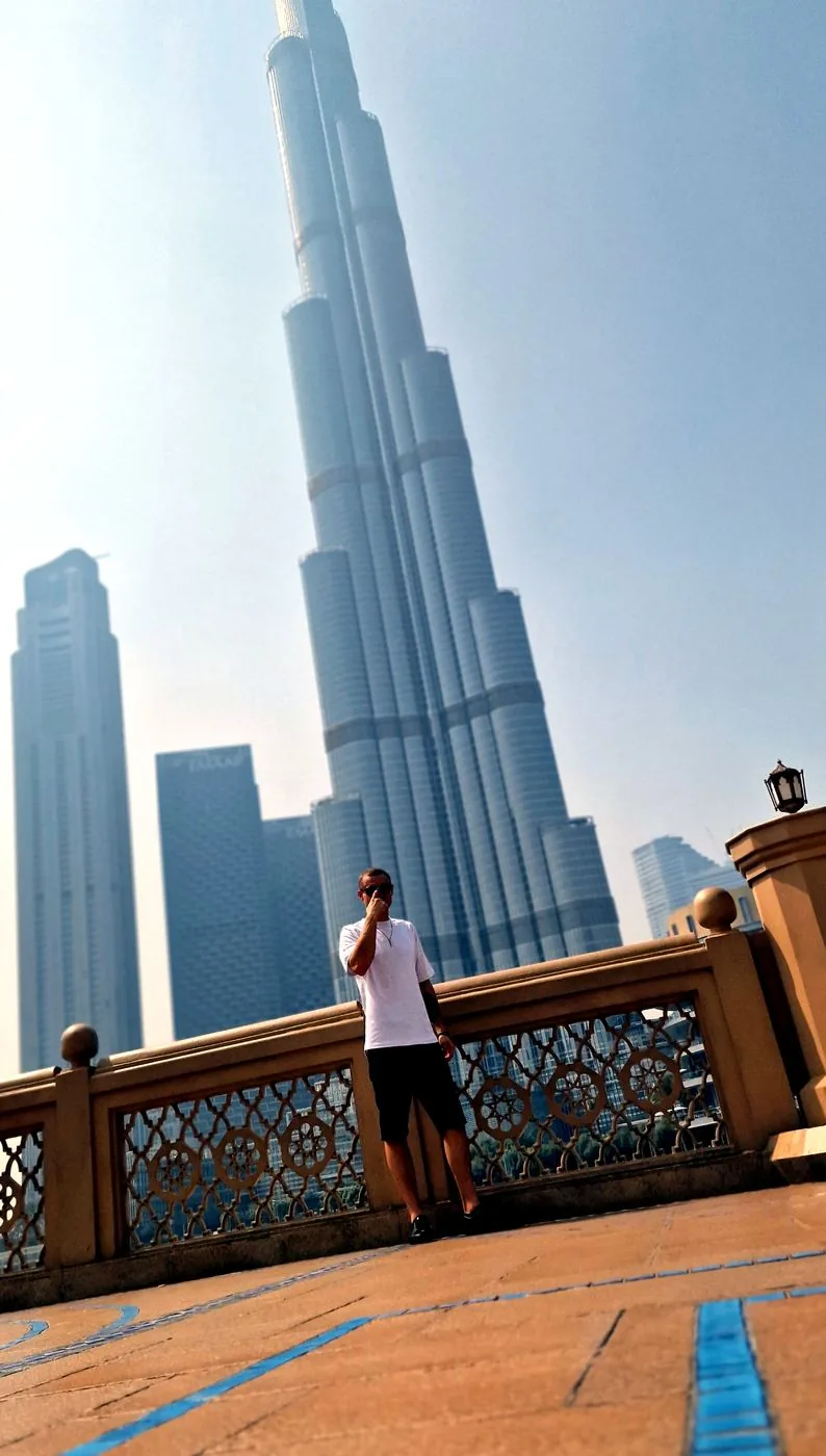 Mann am Geländer, hinter ihm der Burj Khalifa