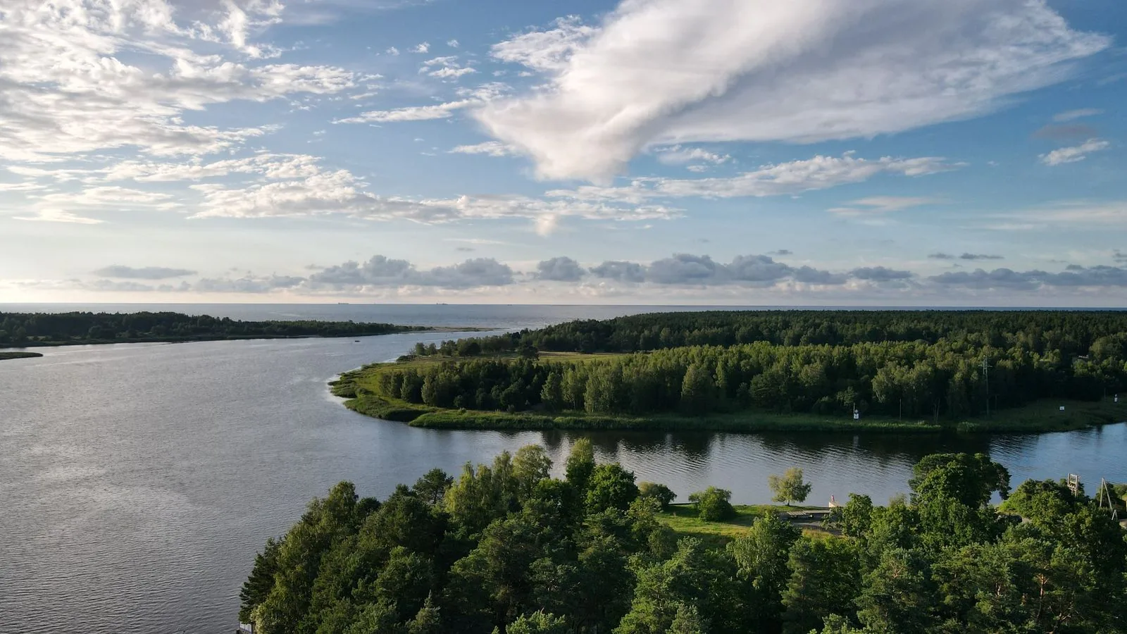 Flussmündung und Meer unter Wolken